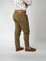 Pantalón de pana negro de corte recto, con bolsillos laterales y traseros. Se ajusta a la cintura con cinturón de cuero negro.