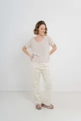 Pantalón de denim color crema con estampado de pequeñas flores rosas y verdes. Corte recto, tiro alto y calce relajado.