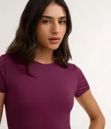 Body de cuello redondo y manga corta, confeccionado en tejido de poliamida con elastano. Presenta un diseño liso y ajustado al cuerpo con cierre en la entrepierna.