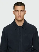 Chaqueta de gamuza azul marino de la marca Boss, modelo Nappalan. Presenta cierre frontal de botones, cuello camisero, bolsillos frontales tipo parche y mangas largas.