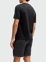 Set de ropa de descanso compuesto por una remera negra de manga corta con cuello redondo y el logo "BOSS" en blanco en el pecho, y un short estampado en tonos de gris oscuro con un patrón repetitivo.