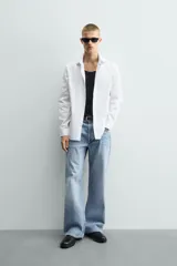 Camisa de corte slim fit confeccionada en tejido de algodón con textura. Presenta cuello italiano, manga larga con puños abotonados y cierre frontal de botones.