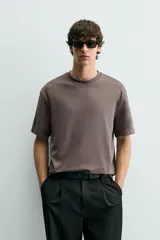 Camiseta de corte relajado con cuello redondo y manga corta, confeccionada en tejido de algodón liso.