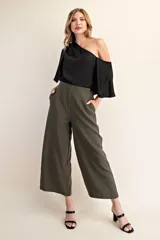 Top negro con diseño asimétrico de un solo hombro y manga tipo capa fluida. Confeccionado en tela ligera y suave, presenta un corte elegante que se ajusta al cuerpo.