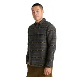 Camisa de manga larga Roark modelo Nordsman, confeccionada en tejido de mezcla de lana con diseño de rayas horizontales y patrones étnicos en tonos amarillos y rojos sobre base gris. Presenta cuello clásico, cierre frontal con botones y dos bolsillos en el pecho.