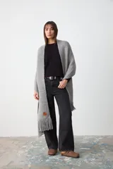 Chal de punto grueso con textura, color gris, confeccionado en una mezcla de lana merino extrafina, lino y viscosa. Diseño ligero y suave con caída envolvente.