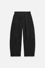 Pantalón fluido confeccionado en mezcla de modal, de tiro medio con cintura elástica ajustable con cordón y bolsillos laterales, en color tostado.