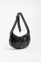 Bolso de hombro de tamaño pequeño con estructura blanda, confeccionado en material sintético con acabado brillante efecto charol. Presenta cierre de cremallera, asa ajustable con detalle de hebilla metálica y logo de la marca en la parte frontal.
