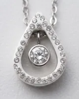 Collar de acero con dije en forma de gota adornado con circonias pavé y una piedra central colgante.