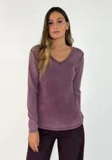 Remera de manga larga con cuello en V y detalle de terminación desflecada en el escote. Presenta un acabado de efecto lavado en tono violeta.