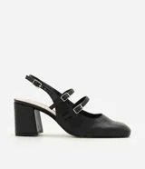 Zapato estilo Mary Jane de color negro, confeccionado en poliuretano con diseño cerrado y puntera cuadrada. Presenta tres tiras cruzadas en el empeine con hebillas metálicas ajustables, tira trasera con hebilla y taco bloque ancho.