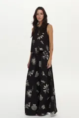 Pantalón palazzo negro con estampado artesanal en tonos claros, cintura elastizada, bolsillos laterales y aberturas en las piernas.