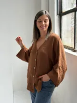 Camisa de lino color tabaco, con escote en V y cierre frontal con botones.