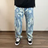 Pantalón jean cargo celeste con efecto tie dye blanco y corte super baggy.