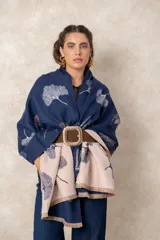 Pashmina reversible de textura suave y caída fluida, con diseño estampado de hojas de ginkgo. Presenta un lado en color azul marino con estampado claro y el reverso en color beige con estampado oscuro, finalizando en ambos extremos con flecos cortos deshilachados.