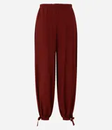 Pantalón estilo aladino color bordó, confeccionado en tejido crepé con textura. Presenta cintura elástica, corte holgado en las piernas y ruedo ajustado con lazo decorativo.
