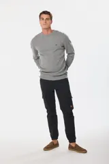 Pantalón cargo azul marino con bolsillos laterales con solapa y cinturón de cuero marrón.