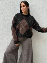 Sweater de punto con diseño de rombos en tonos bordó y beige, cuello redondo y mangas largas con puños acanalados.