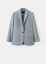Blazer de corte sastrero en color gris azulado, con cierre frontal de un botón, solapas clásicas y bolsillos laterales con solapa.