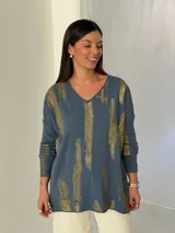 Sweater de punto color azul jean con estampado de pinceladas doradas brillantes, cuello en V y mangas largas.