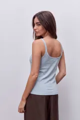 Musculosa básica celeste de calce ajustado, confeccionada en tejido acanalado, con escote redondo y breteles finos.