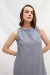 Vestido midi color beige de lino, sin mangas y con escote redondo.