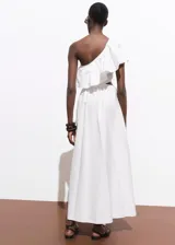 Vestido midi color blanco de diseño evasé y corte asimétrico con un hombro descubierto. Cuenta con un volante grande en el escote, detalles cut-out en la cintura y falda larga y amplia con bolsillos.