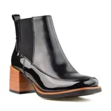 Bota corta negra charolada con elásticos laterales, punta cuadrada y taco geométrico de madera.