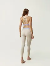 Calza 7/8 azul con cintura alta blanca y logo en la pierna.