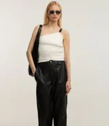 Pantalón negro de cuero sintético, corte recto, con bolsillos delanteros grandes y cierre con botón y cremallera.