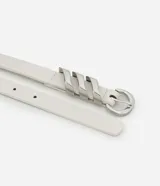 Kit de dos cinturones medianos para mujer, uno blanco con hebilla redonda plateada y detalle metálico triple, y otro marrón con hebilla cuadrada plateada y detalle metálico en forma de X.