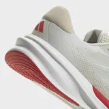 Championes de running Adidas modelo Supernova Stride 2, color gris claro con detalles en rojo. Presentan un exterior de malla transpirable, mediasuela Dreamstrike+ para mayor comodidad y suela Adiwear para un agarre duradero.