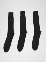 Pack de tres pares de medias de vestir negras con logo Calvin Klein. Un par con diseño geométrico, otro liso y otro con pequeños lunares.