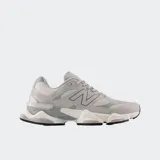 Championes urbanos New Balance modelo 9060, color gris con detalles en tonos más oscuros y claros. Presentan un diseño robusto con suela de plataforma esculpida, combinación de malla y superposiciones sintéticas, y el logo 'N' característico en el lateral.