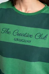 Sweater de algodón peinado con diseño de rayas horizontales en tonos verde oscuro y verde claro, de corte holgado y manga larga, con detalle de bordado en el pecho.