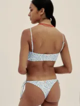 Conjunto de bikini con estampado de cebra en tonos celeste y blanco. El corpiño es de corte recto con tirantes finos y la bombacha es tipo colaless con tiras ajustables en los laterales.
