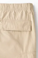 Pantalón cargo de lona de algodón con corte relajado, bolsillos laterales con solapa, bolsillos al bies y pliegues reforzados en las rodillas.
