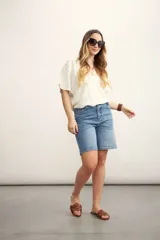 Blusa blanca con diseño cruzado, escote en V y mangas cortas.