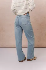 Pantalón de jean tiro alto con calce wide leg, color celeste claro con lavado suave y detalle de desgaste en el bolsillo delantero.
