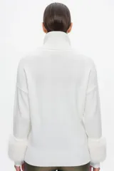 Sweater blanco de cuello alto con puños de piel sintética.