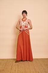 Vestido largo color terracota de tirantes, con detalles de cordones decorativos en color crudo en la parte frontal y falda amplia de corte fluido.