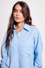 Camisa oversize de lino y viscosa color celeste, con cuello clásico, cierre frontal con botones y mangas largas.