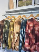 Remera de manga larga con diseño estampado de flores en tonos marrones y destellos de lurex. Presenta un corte holgado, cuello redondo y puños en color gris claro.