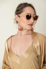 Aros colgantes con forma de caracola en tonos tostado y dorado.