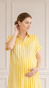 Camisa maternal de corte holgado y manga corta, confeccionada en viscosa suave con estampado de círculos azules sobre fondo blanco. Presenta cuello clásico y bolsillos frontales.