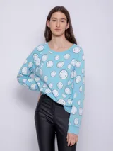 Buzo celeste de tela deportiva con estampado de caritas felices blancas. Es de manga larga y cuello redondo.