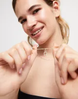 Dije plateado con forma de herradura con pequeños cristales incrustados.