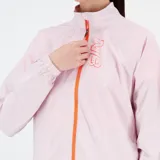 Campera deportiva New Balance color rosa pálido con cierre frontal naranja, logo NB en el pecho y detalles reflectantes.
