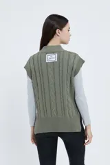 Chaleco tejido color verde oliva con cuello en V y diseño de trenzas.