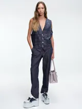 Chaleco sastrero de denim negro con diseño de cuadros y aplicación de lentejuelas sutiles. Presenta escote en V, cierre frontal con botones metálicos y bolsillos delanteros.